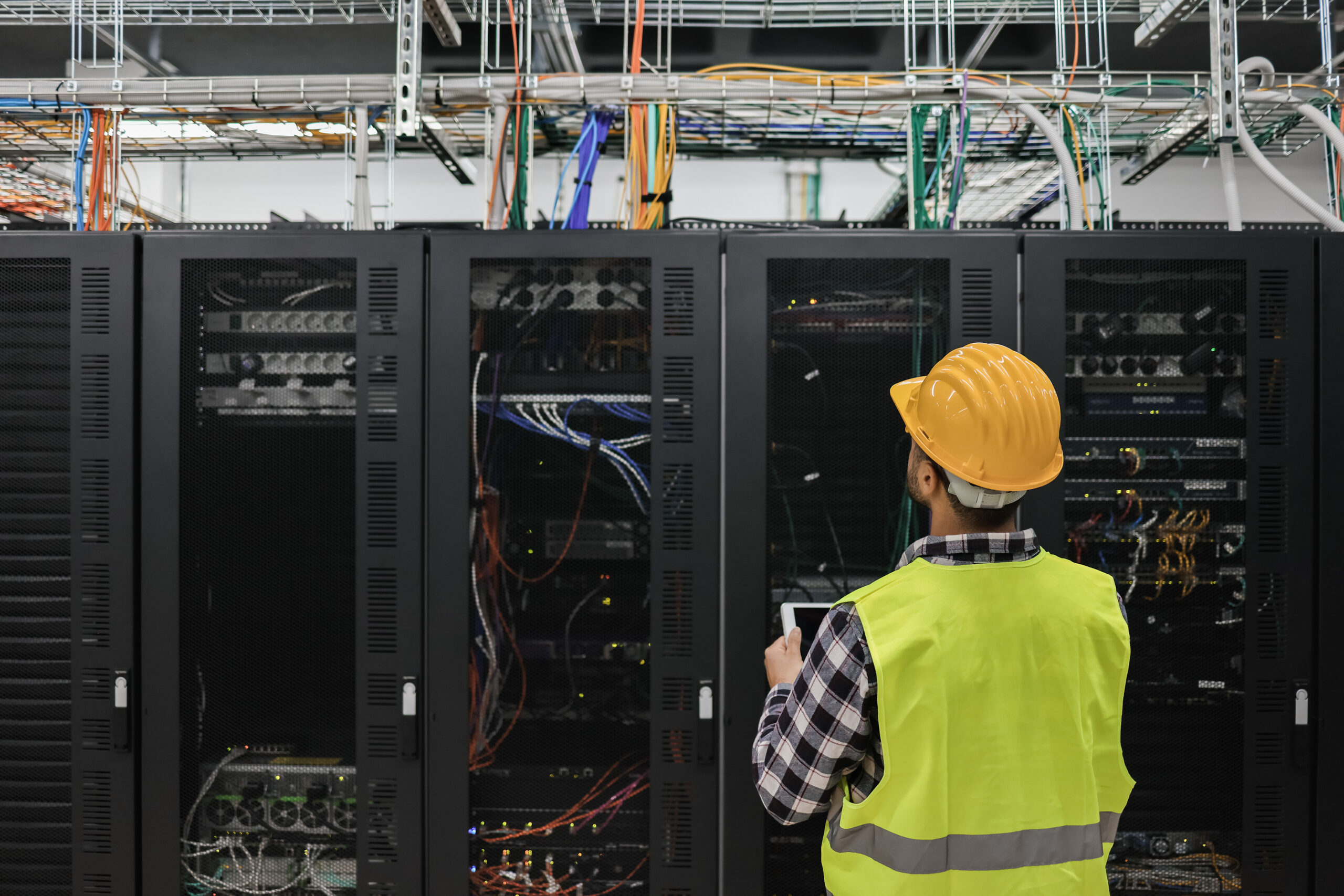 Young technician man working with tablet inside big data center Quality components tailored to the consumer products sector